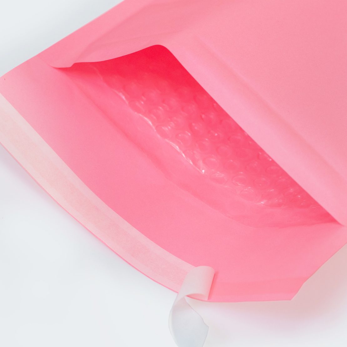 Różowa koperta bąbelkowa, zbliżenie otwartej koperty, folia bąbelkowa w środku
